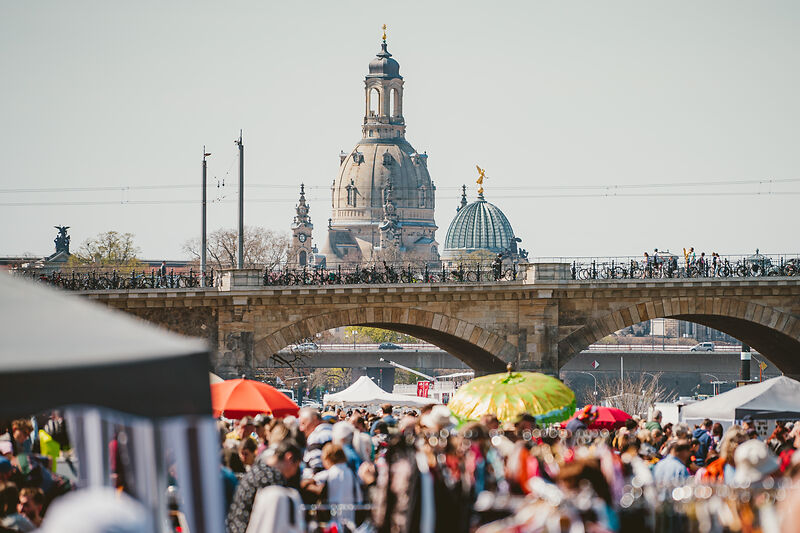 Der Elbeflohmarkt an der Albertbrücke gilt als der schönste Flohmarkt Dresdens und ist ein wöchentliches Highlight für Flohmarktliebhaber. Jeden Samstag versammeln sich bis zu 500 Händler, um ihre Stände auf dem beeindruckenden Markt aufzubauen. Das weitläufige Areal bietet eine schier unendliche Vielfalt an Schätzen und Kuriositäten. Von Schallplatten über Knopfsammlungen bis hin zu Vintage-Mänteln aus den 1970er Jahren und exquisiten Stoffen ist für jeden Geschmack etwas dabei. Auch umfangreiche Geschirrsammlungen warten darauf, bestaunt zu werden. Foto: Sebastian Weingart (DML-BY) --- The Elbe flea market at the Albert Bridge is considered the most beautiful flea market in Dresden and is a weekly highlight for flea market lovers. Every Saturday, up to 500 traders gather to set up their stalls at the impressive market. The spacious area offers a seemingly endless variety of treasures and curiosities. From records and button collections to vintage coats from the 1970s and exquisite fabrics, there is something for everyone. Extensive collections of tableware are also waiting to be marvelled at. Photo: Sebastian Weingart (DML-BY)